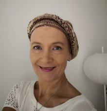 Kirjoittaja Jaana Pakarinen hymyilee iloisesti läheltä otetussa kasvokuvassa.