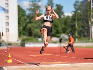 Nainen hyppää pituutta paralympialaisissa, kesäinen sää.