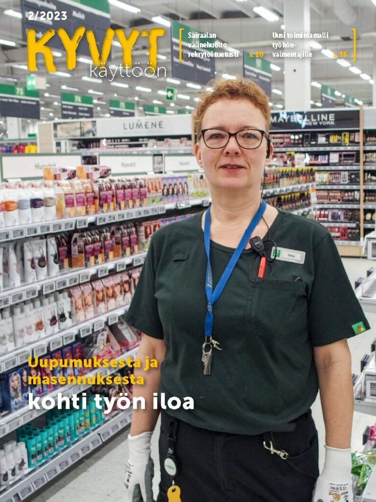 Kyvyt käyttöön -lehden nro 2 2023 kansi, jossa lyhythiuksinen henkilö seisoo myymälässä, työntekijä. Taustalla kosmetiikkatuotehyllyjä.