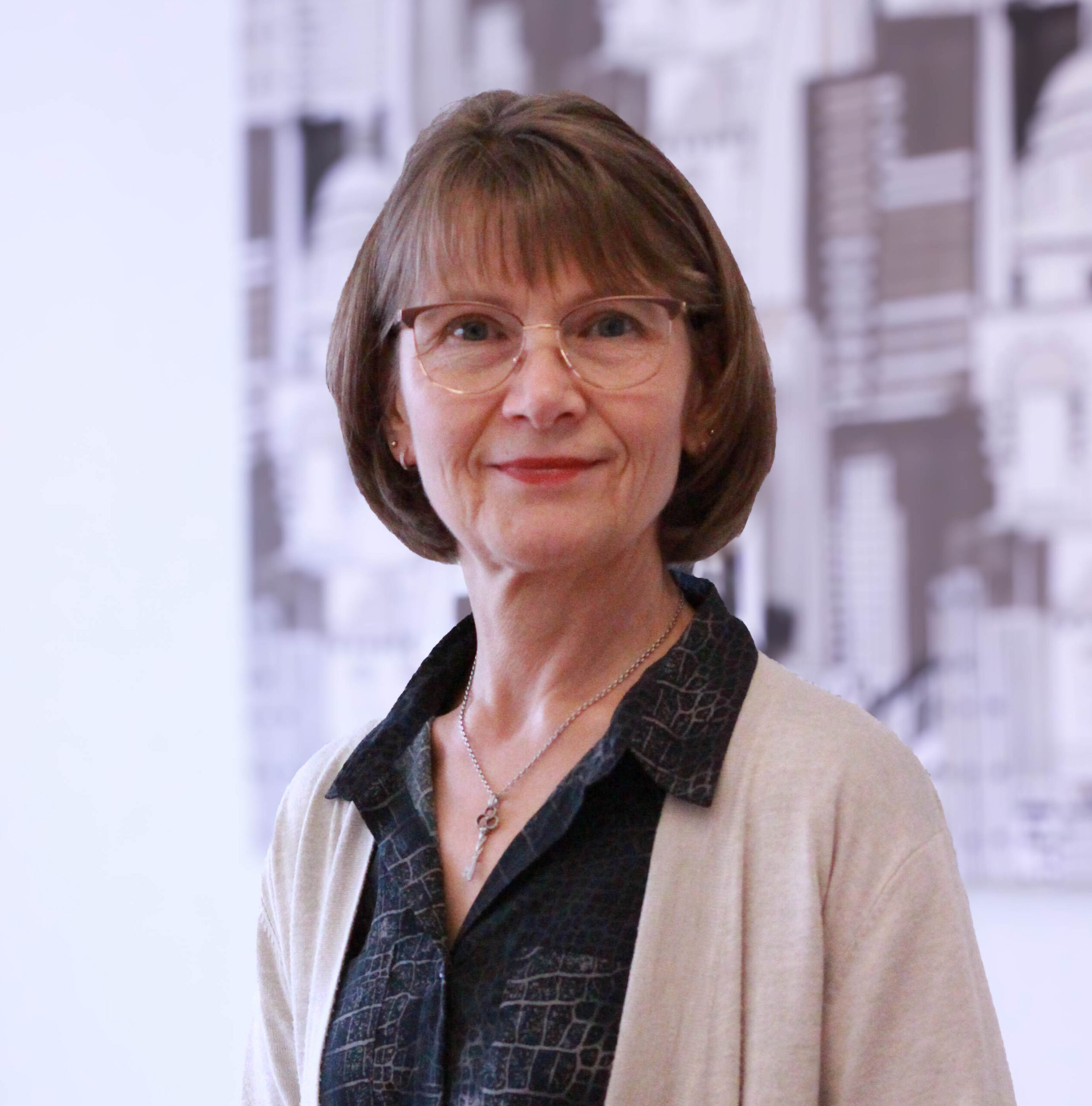 Ruskeahiuksinen nainen katsoo suoraan kameraan. 