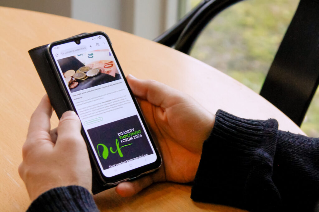 Lähikuvassa henkilö katsoo puhelimelta Vatesin verkkosivuja.