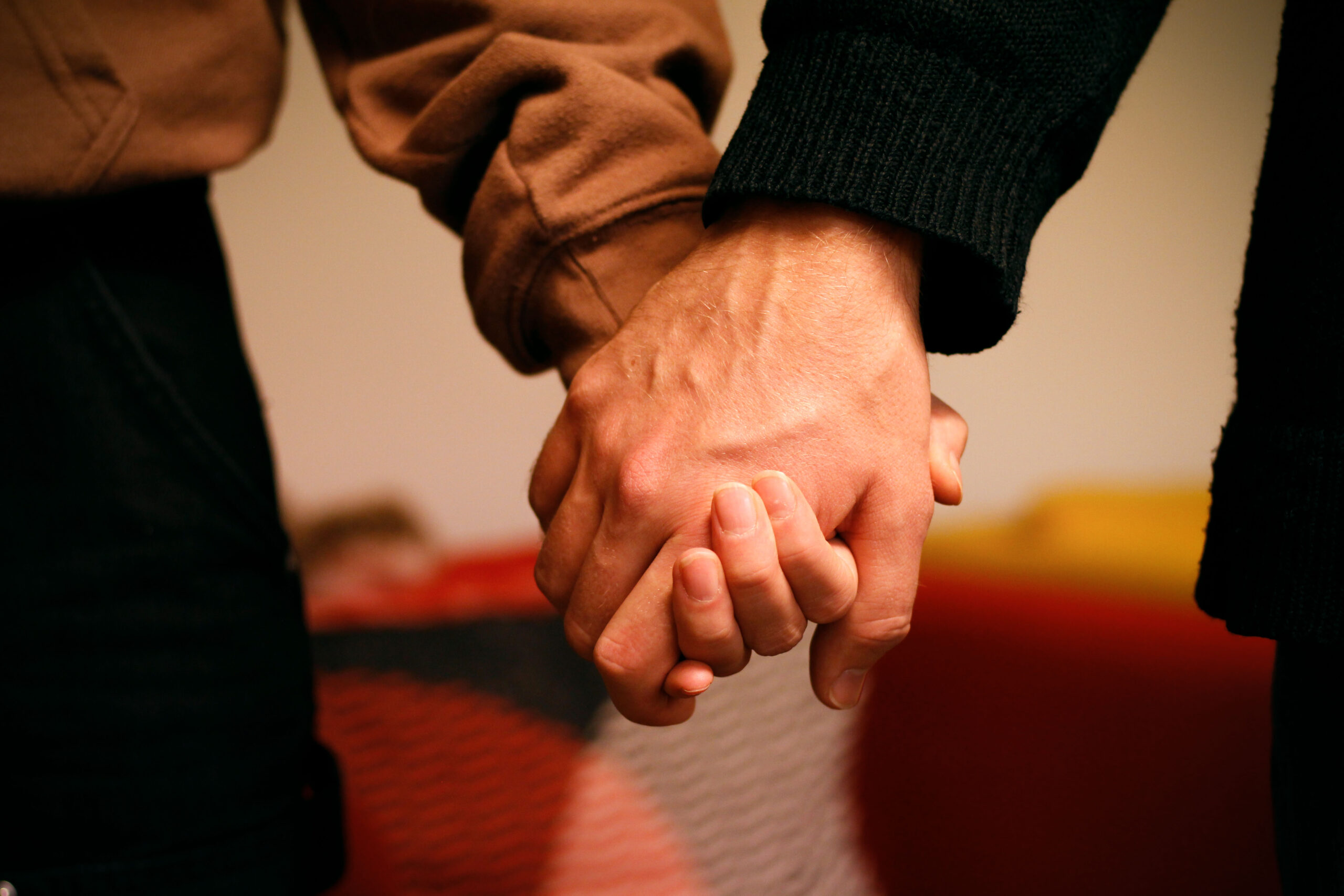 Kaksi ihmistä pitää toisiaan kädestä kiinni.