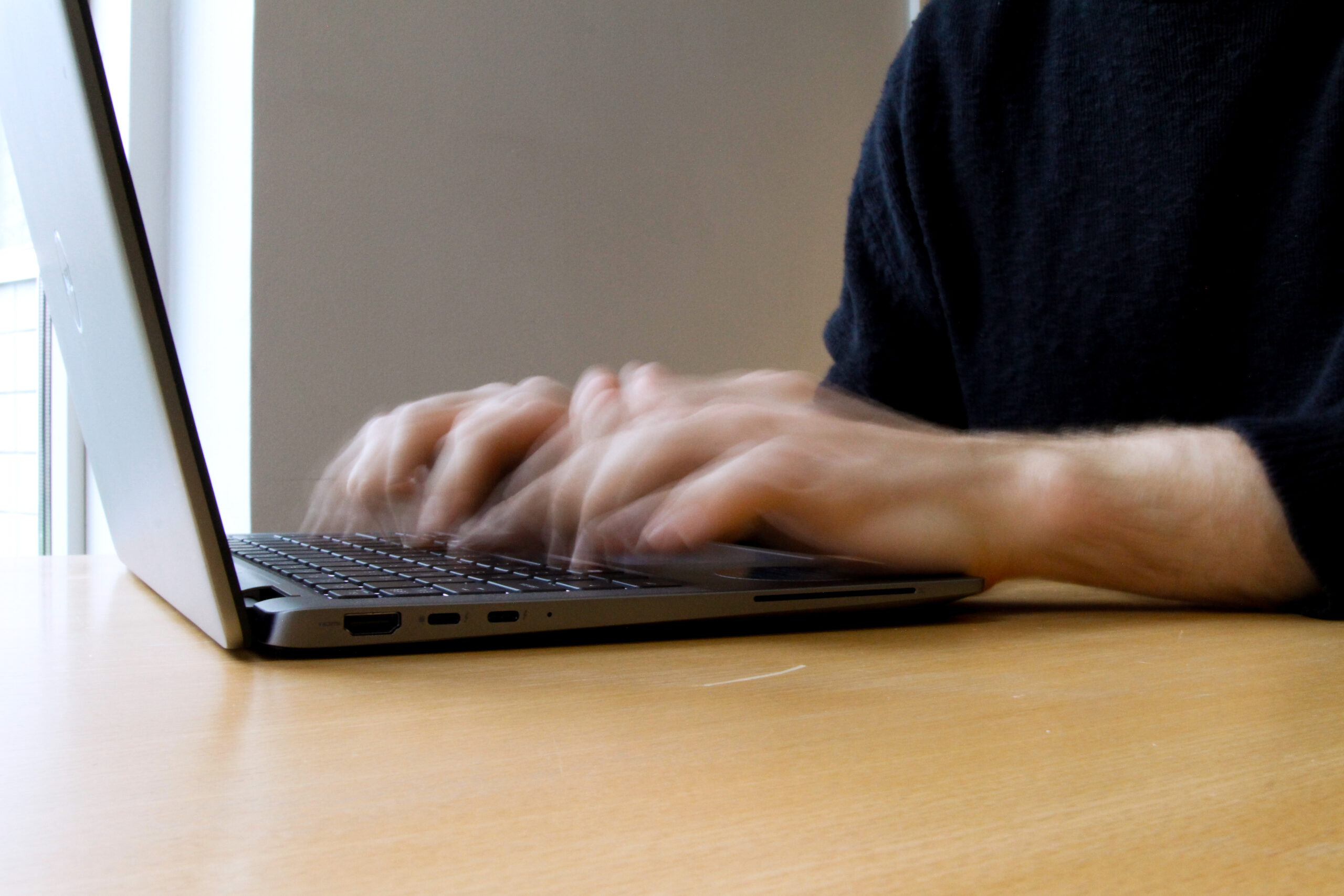 Sormet näpyttävät läppärin näppäimistöä.