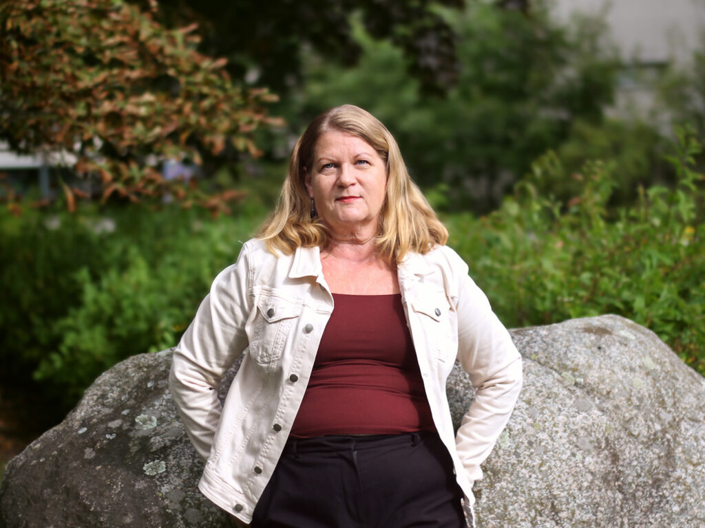 Kaija Ray nojaa kiveen kesäisessä puistossa.