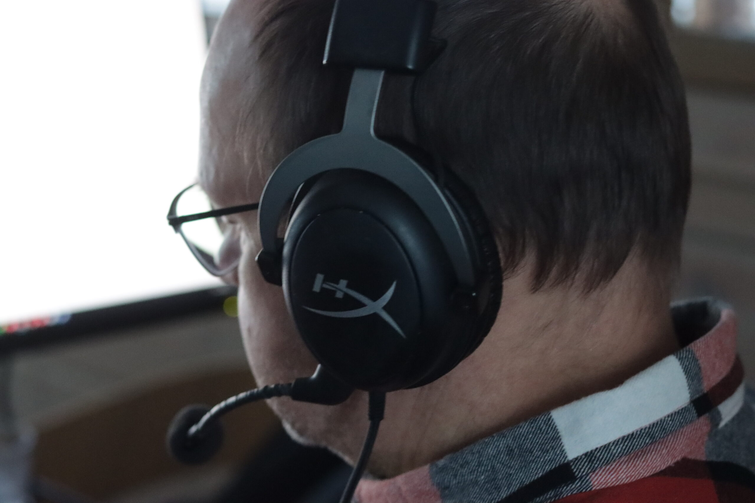 Mies, jolla luurit päässä tietokoneella. 