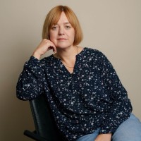 Jurgita nojaa kämmeneen ja katsoo kameraan.